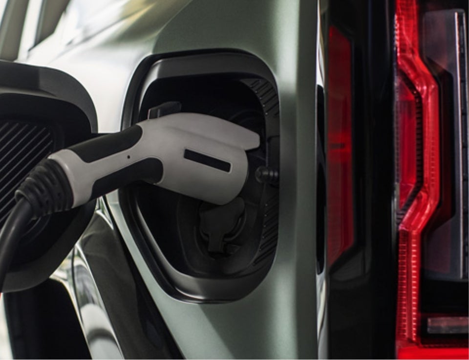 Close up of charging port with charger plugged in on a GMC Hummer EV SUV - Serra Buick GMC Rochester Hills in Rochester Hills MI